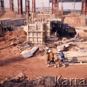 Marzec 1975, Dąbrowa Górnicza, woj. Katowice, Polska.
Budowa Huty Katowice, fragment placu budowy, z prawej trzej robotnicy w odzieży ochronnej i kaskach.
Fot. Romuald Broniarek/KARTA
