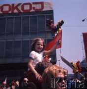 1.05.1975, Warszawa, Polska. 
Obchody święta 1 Maja, uczestnicy pochodu przechodzą ulicą Marszałkowską, na pierwszym planie dziewczynka siedząca na ramionach ojca.
Fot. Romuald Broniarek/KARTA
