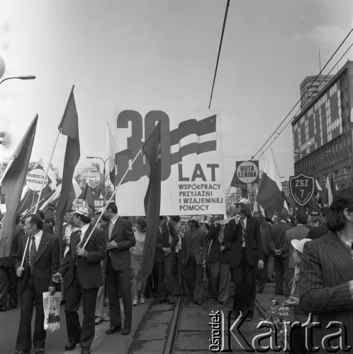1.05.1975, Warszawa, Polska. 
Obchody święta 1 Maja, uczestnicy pochodu przechodzą ulicą Marszałkowską niosąc flagi i hasło: 