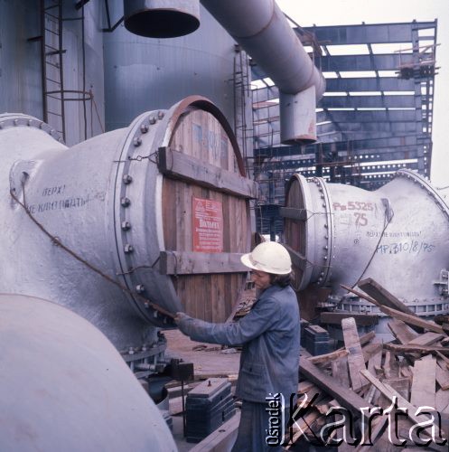 Październik 1975, Dąbrowa Górnicza, woj. Katowice, Polska.
Budowa Huty Katowice, robotnik w kasku ochronnym oglądający stalowe elementy importowane ze Związku Radzieckiego.
Fot. Romuald Broniarek/KARTA
