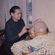 Luty 1976, Bratysława, Czechosłowacja
Koronczarka podcza pracy - wyrób koronek metodą klockową. Koronka klockowa wykonywana jest przez splatanie ze sobą nici nawiniętych na szpulki zwane klockami. Wzór koronki jest narysowany na kalce technicznej i przypięty do wałka wypchanego trocinami.
Fot. Romuald Broniarek/KARTA
