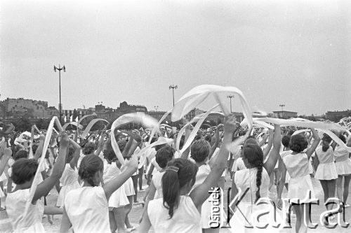 22.07.1959, Warszawa, Polska. 
Obchody piętnastolecia PRL, defilada wojskowo-sportowa, kobiety w strojach sportowych machające białymi wstążkami, w tle budynki przy ulicy Marszałkowskiej.
Fot. Romuald Broniarek/KARTA