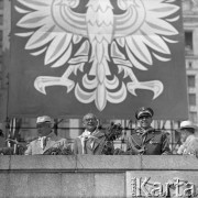 22.07.1959, Warszawa, Polska. 
Minister obrony narodowej gen. Marian Spychalski dokonuje przeglądu wojsk podczas defilady z okazji piętnastolecia PRL, na trybunie honorowej od lewej stoją I sekretarz KPZR Nikita Chruszczow, I sekretarz KC PZPR Władysław Gomułka, gen. Marian Spychalski, nad nimi fragment godła PRL. 
Fot. Romuald Broniarek/KARTA