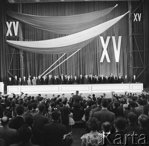 21.07.1959, Warszawa, Polska. 
Akademia w przeddzień piętnastolecia PRL, na pierwszym planie widownia, dalej dziennikarze. Na drugim planie trybuna honorowa, na niej  przed mikrofonem przewodniczący Rady Państwa Aleksander Zawadzki, na lewo od niego I sekretarz KC KPZR Nikita Chruszczow, I sekretarz KC PZPR Władysław Gomułka, drugi na prawo od Zawadzkiego premier Józef Cyrankiewicz. 
Fot. Romuald Broniarek/KARTA