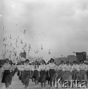 22.07.1959, Warszawa, Polska.
Uroczyste obchody piętnastolecia PRL, kobiety idące w defiladzie, na drugim planie flagi i balony, w tle budynki przy ulicy Marszałkowskiej. 
Fot. Romuald Broniarek/KARTA