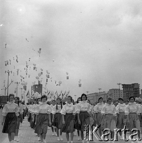 22.07.1959, Warszawa, Polska.
Uroczyste obchody piętnastolecia PRL, kobiety idące w defiladzie, na drugim planie flagi i balony, w tle budynki przy ulicy Marszałkowskiej. 
Fot. Romuald Broniarek/KARTA