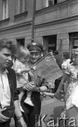 Lipiec 1959, Warszawa, Polska.
Uroczyste obchody piętnastolecia PRL. Warszawiacy czekają na przejazd radzieckiej delegacji. Na zdjęciu milicjant z córką.
Fot. Romuald Broniarek/KARTA