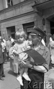 Lipiec 1959, Warszawa, Polska.
Uroczyste obchody piętnastolecia PRL. Warszawiacy czekają na przejazd radzieckiej delegacji. Na zdjęciu milicjant z córką.
Fot. Romuald Broniarek/KARTA