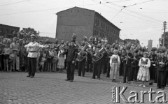 Lipiec 1959, Katowice, Polska.
Obchody piętnastolecia PRL, orkiestra górnicza na trasie przejazdu radzieckiej delegacji z Nikitą Chruszczowem na czele. Z lewej stoi milicjant kierujący ruchem.
Fot. Romuald Broniarek/KARTA