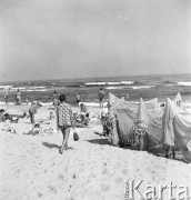 Lipiec 1959, Jastarnia, Polska.
Wypoczynek nad Bałtykiem - wczasowicze na plaży, z prawej suszą się sieci rybackie.
Fot. Romuald Broniarek/KARTA