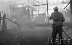 Sierpień 1959, Sandomierz, Polska.
Strażak z sikawką gasi płonący budynek.
Fot. Romuald Broniarek/KARTA