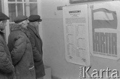 Styczeń 1978, Jazgarzew k/Warszawy, Polska.
Spotkanie przed wyborami do gminnych Rad Narodowych, trzej mężczyźni czytający obwieszczenie. Z prawej wisi plakat: 