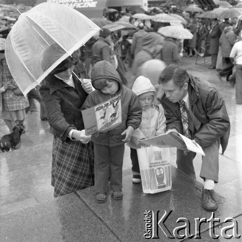 Maj 1978, Warszawa, Polska.
Kiermasz książki przed Pałacem Kultury i Nauki, na pierwszym planie rodzina oglądająca zakupione książki, dziecko po lewej stronie ogląda rosyjską książeczkę edykuacyjną 