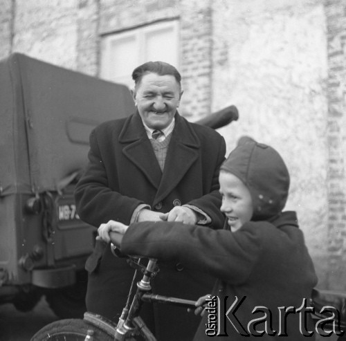 1959, pow. Siedlce, woj. Warszawa, Polska. 
Objazdowe kino Towarzystwa Przyjaźni Polsko-Radzieckiej w wiejskiej szkole. Mężczyzna i chłopiec przy rowerze.
Fot. Romuald Broniarek/KARTA