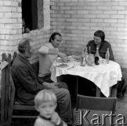 Październik 1981, Wola Osowińska k/Kocka, woj. Lublin, Polska.
Impreza po świniobiciu, trzej mężczyźni siedzący przy zastawionym stole.
Fot. Romuald Broniarek/KARTA