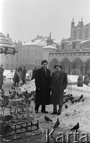 Styczeń 1960, Kraków, Polska.
VI Krajowy Zjazd TPPR, członkowie radzieckiej delegacji na krakowskim Rynku wśród gołębi, na pierwszym planie karmniki dla ptaków leżące na sankach. W tle fragment Sukiennic.
Fot. Romuald Broniarek/KARTA