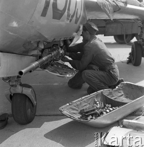 Sierpień 1960, Kraków, Polska.
Ćwiczenia Wojsk Lotniczych, mechanicy zakładają taśmy amunicyjne do karabinów maszynowych samolotu.
Fot. Romuald Broniarek/KARTA