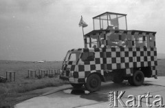 Sierpień 1960, Kraków, Polska.
Ćwiczenia Wojsk Lotniczych, na pierwszym planie samochód pomalowany w szachownicę.
Fot. Romuald Broniarek/KARTA