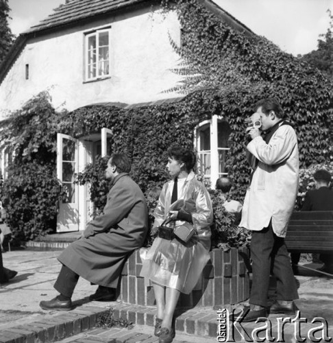 Wrzesień 1960, Żelazowa Wola, Polska.
Artyści z Teatru Bolszoj przed Muzeum Fryderyka Chopina, w środku siedzi kobieta w płaszczu przeciwdeszczowym. Z prawej stoi mężczyzna z kamerą.
Fot. Romuald Broniarek/KARTA