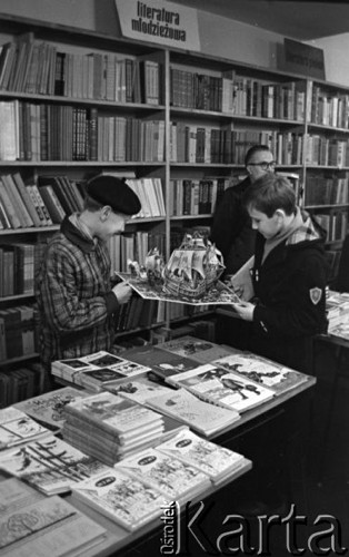 Grudzień 1960, Warszawa, Polska.
Księgarnia radziecka przy ul. Nowy Świat, dwaj chłopcy oglądają rozkładaną książkę.
Fot. Romuald Broniarek/KARTA