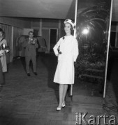 Luty 1961, Warszawa, Polska.
Pokaz modeli z kolekcji wiosna-lato Mody Polskiej, modelka w jasnym kostiumie na tle lustra.
Fot. Romuald Broniarek/KARTA