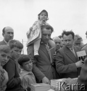 Maj 1961, Warszawa, Polska.
Kiermasz książki w Alejach Ujazdowskich, kupujący przy stoisku. W środku stoi mężczyzna z dziewczynką na ramionach.
Fot. Romuald Broniarek/KARTA