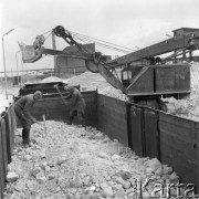 Sierpień 1961, Tarnobrzeg, Polska. 
Kopalnia siarki, dwaj robotnicy rozbijają bryły surowca w w wagonie towarowym. W tle koparka.
Fot. Romuald Broniarek/KARTA