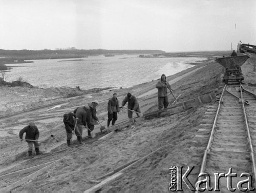 Listopad 1962, Dębe k/Warszawy, Polska. 
Budowa stopnia wodnego zamykającego koryto Narwi, robotnicy pracujący na nasypie.
Fot. Romuald Broniarek/KARTA