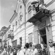 Lipiec 1962, Sandomierz, Polska. 
Międzynarodowy Wyścig Przyjaźni Polsko-Ukraińskiej im. płk Wasyla Skopenki - publiczność na ulicy i balkonie nad zakładem fryzjerskim Jana Perły.
Fot. Romuald Broniarek/KARTA