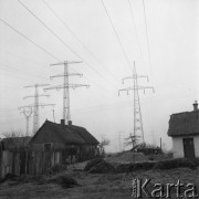 Listopad 1962, Konin (okolice), Polska.
Budowa Kopalnia Węgla Brunatnego w okolicach Konina - na pierwszym planie wiejskie chaty, w tle słupy wysokiego napięcia.
Fot. Romuald Broniarek/KARTA