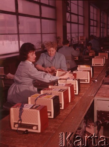 Styczeń 1963, Warszawa, Polska.
Pracownice Zakładów Radiowych im. Marcina Kasprzaka siedzą przy taśmie produkcyjnej, na której stoją radioodbiorniki 