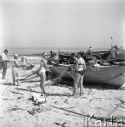 Lipiec 1963, Krynica Morska, Polska.
Łodzie rybackie na plaży, dziewczyny w strojach kąpielowych pomagają rozłożyć sieci rybackie.
Fot. Romuald Broniarek/KARTA