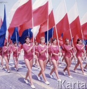 22.07.1964, Warszawa, Polska.
Plac Defilad, uroczyste obchody dwudziestolecia PRL - grupa dziewcząt w czerwonych strojach sportowych niesie biało-czerwone i granatowe flagi.
Fot. Romuald Broniarek/KARTA