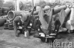 Październik 1964, Elbląg, Polska.
Pracownik Zakładów Mechanicznych im. Generała Karola Świerczewskiego maluje kotwice okrętowe.
Fot. Romuald Broniarek/KARTA