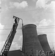 1965, Bogatynia, Polska.
Dymiące kominy Elektrowni Turów, na pierwszym planie robotnicy na drabinie montują lampę oświetleniową.
Fot. Romuald Broniarek/KARTA