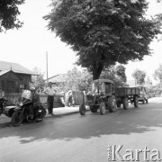 Lipiec 1965, Polska.
Milicjant na motocyklu z przyczepą, z tyłu traktor i samochód marki 