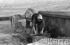 Luty 1969, brak miejsca, Lubelszczyzna, Polska.
Kobieta piorąca przy studni.
Fot. Romuald Broniarek/KARTA