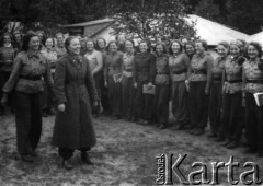 Lipiec- 15.08.1939, Garczyn k/Kościerzyny, Pomorskie woj., Polska.
Uczestniczki obozu Przysposobienia Wojskowego Kobiet, pożegnanie jednej z komendantek [stoi w długim płaszczu], która wyjeżdżała wcześniej, aby pożegnać się ze zmobilizowanym mężem.
Fot. NN, zbiory Ośrodka KARTA, udostępniła Aldona Nikoniuk.

