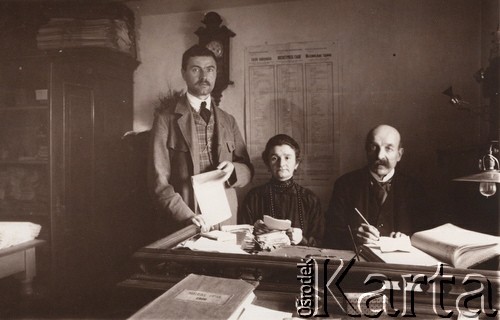 1916, Lwów
 Pracownicy urzędu - komisja przyjmująca od osób fizycznych Podatki na cele wojskowe, na stole leży księga z tytułem: 