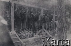 Lata 40-te, brak miejsca.
Niemieccy żołnierze przyglądający się ofiarom egzekucji wiszącym na szubienicy.
Fot. NN, zbiory Ośrodka KARTA