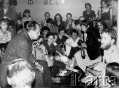 1980, Warszawa.
Czesław Miłosz na spotkaniu z czytelnikami w mieszkaniu Bąkowskich, z prawej siedzi Mirosław Chojecki, za nim Piotr Szwajcer, w środku w czarnej koszulce Magdalena Boguta, za nią na lewo Piotr Bąkowski i Zofia Winawer, w środku przy ścianie Magdalena Boguta.
Fot. Marcin Jabłoński, zbiory Ośrodka KARTA