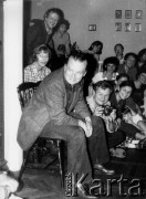 1980, Warszawa.
Czesław Miłosz na spotkaniu z czytelnikami w mieszkaniu Bąkowskich, z lewej stoją: Adam Michnik i Tomasz Jastrun, w środku [w białej bluzce] Zofia Winawer, obok niej Paweł Bąkowski, z prawej Magdalena Bocheńska.
Fot. Marcin Jabłoński, zbiory Ośrodka KARTA