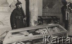 Po 18.05.1935, Kraków, Polska.
Warta przy szklanej trumnie Marszałka Józefa Piłsudskiego w krypcie kaplicy św. Leonarda na Wawelu. Widoczny jest również wieniec przytwierdzony do kolumny oraz fragment sarkofagu.
Fot. NN, zbiory Ośrodka KARTA, kolekcję zdjęć przekazał Marcin Jabłoński.
