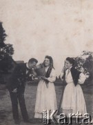 Przed 1914, Rosja.
Sceny z życia wsi - dwie kobiety ubrane w ludowe stroje podają wodę eleganckiemu mężczyźnie.
Fot. NN, zbiory Ośrodka KARTA, kolekcję rodziny Petrulewiczów przekazały Halszka i Wanda Żuromskie