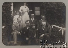 Przed 1914, Rosja.
Grupa osób przed domem, w jasnym garniturze Witold Petrulewicz, z tyłu stoi kobieta w jasnej sukni trzymająca bałałajkę.
Fot. NN, zbiory Ośrodka KARTA, kolekcję rodziny Petrulewiczów udostępniły Halszka i Wanda Żuromskie