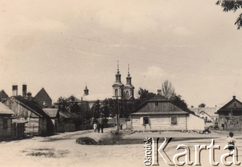 Lata 30-te, brak miejsca, Polska.
Fragment miasta, Na pierwszym planie widoczna jest drewniana zabudowa mieszkalna, przechodnie, w oddali - wieże kościelne.
Fot. NN, zbiory Ośrodka KARTA, kolekcję rodziny Petrulewiczów przekazały Halszka i Wanda Żuromskie