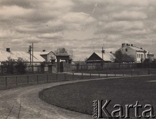 Lata 30-te, Radzyń Podlaski, woj. Lublin, Polska.
Widok na bieżnię i bramę miejskiego stadionu.  W oddali widoczna jest zabudowa mieszkalna.
Fot. Kazimierz Petrulewicz, zbiory Ośrodka KARTA, kolekcję rodziny Petrulewiczów przekazały Halszka i Wanda Żuromskie

