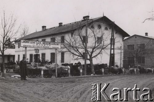 1940-1944, Radzyń Podlaski, woj. Lublin, Polska.
Wozy chłopów z okolicznych wsi obok budynku Powiatowej Spółdzielni Rolniczej.
Fot. Kazimierz Petrulewicz, zbiory Ośrodka KARTA, kolekcję rodziny Petrulewiczów udostępniły Halszka i Wanda Żuromskie