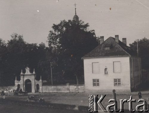 1940-1944, Radzyń Podlaski, woj. Lublin, Polska.
Ulica Lubelska, dom parafialny kościoła pod wezwaniem Świętej Trójcy i zabytkowa brama, za drzewami widoczna wieża kościoła.
Fot. Kazimierz Petrulewicz, zbiory Ośrodka KARTA, kolekcję rodziny Petrulewiczów udostępniły Halszka i Wanda Żuromskie
