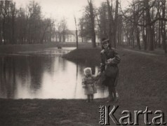 1940-1944, Radzyń Podlaski, woj. Lublin, Polska.
Kobieta z dzieckiem w parku miejskim na tle stawu, w głębi widoczny drewniany domek dla łabędzi w stylu chińskiej pagody oraz pałac Potockich.
Fot. Kazimierz Petrulewicz, zbiory Ośrodka KARTA, kolekcję rodziny Petrulewiczów udostępniły Halszka i Wanda Żuromskie